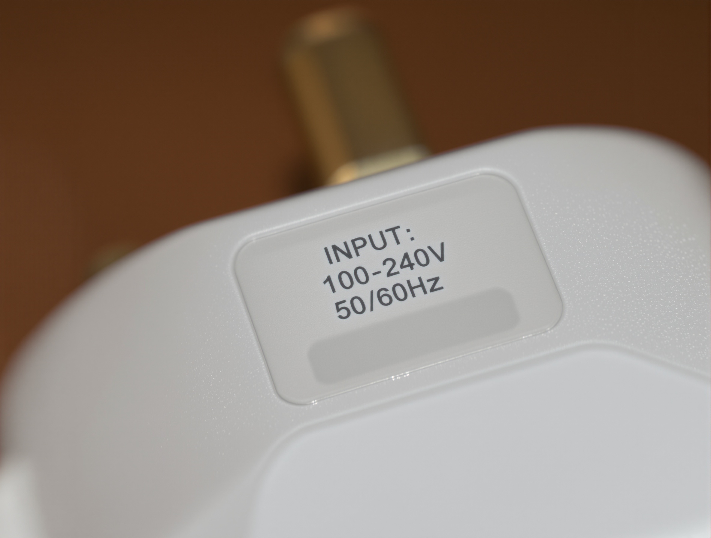 Étiquette chargeur INPUT 100-240V lisible en gros plan