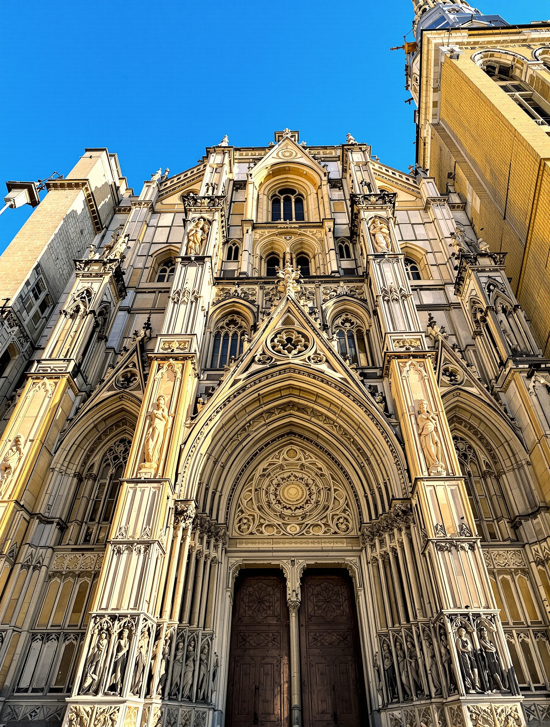 La façade de la Cathédrale Saint-Jean, un livre de pierre sculpté, avec ses trois portails et ses médaillons gothiques qui ont survécu aux fureurs de l'histoire et du temps.