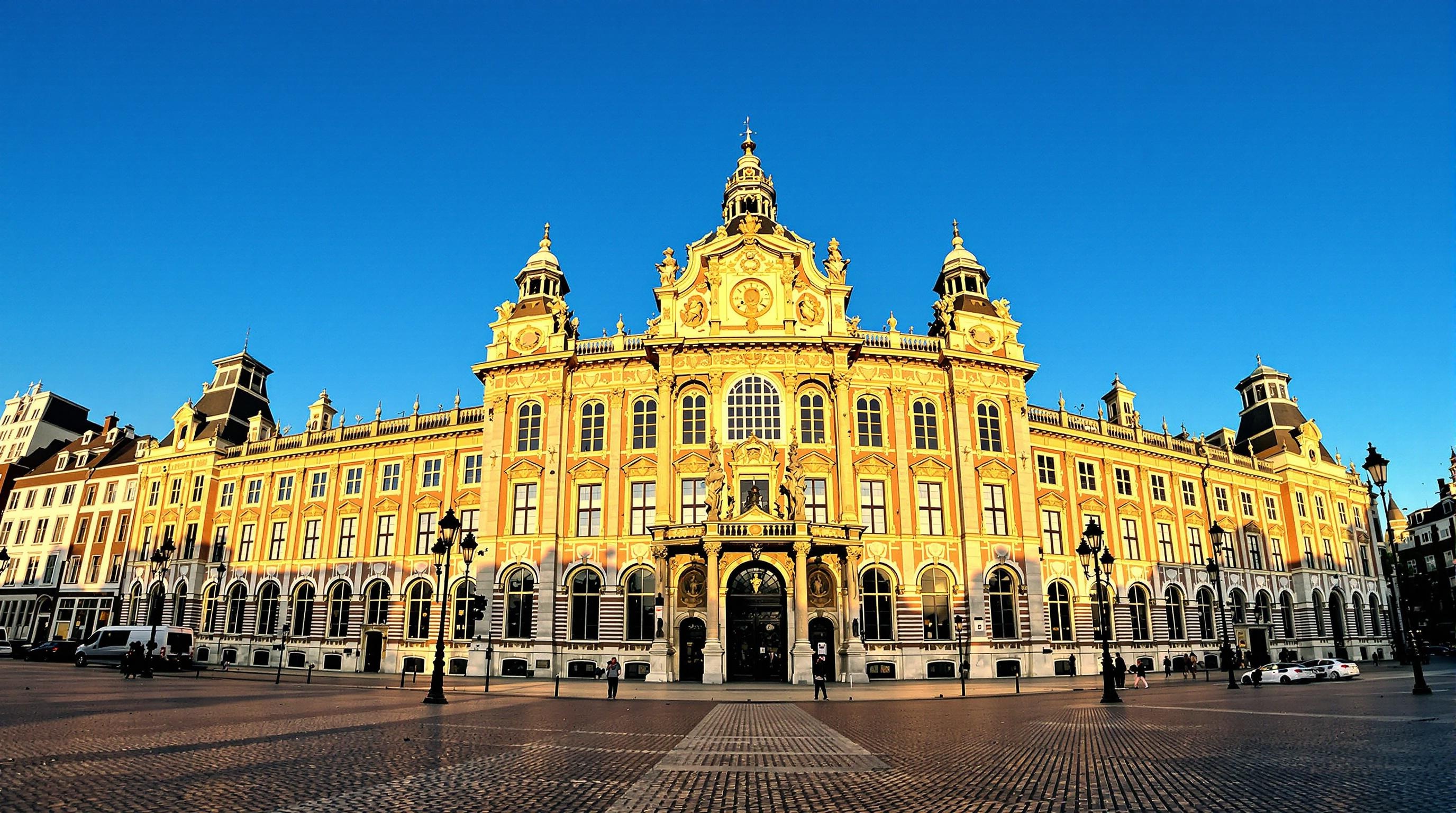 Façade du Palais Royal sur la Place du Dam baignée de lumière matinale