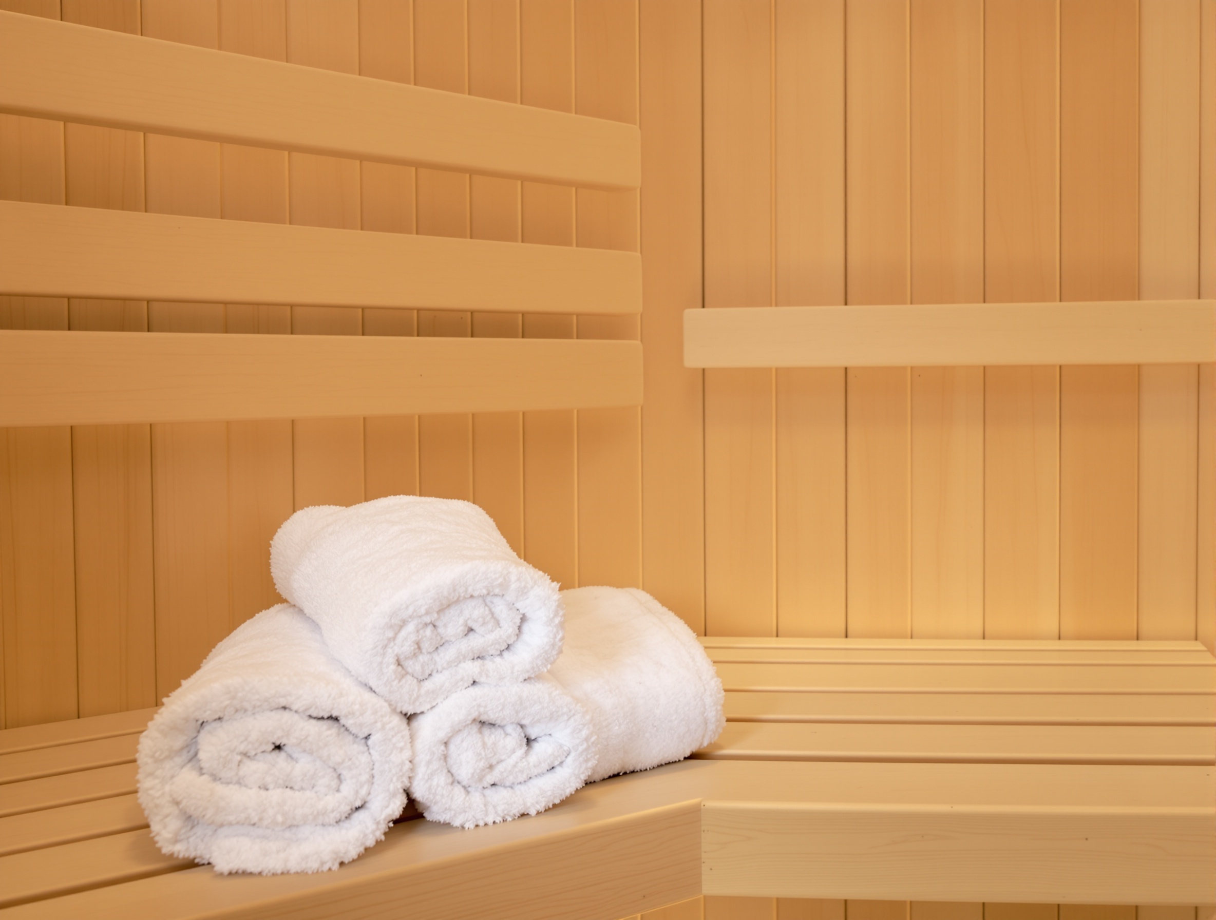 Intérieur d'un sauna moderne en bois clair, très propre et calme.