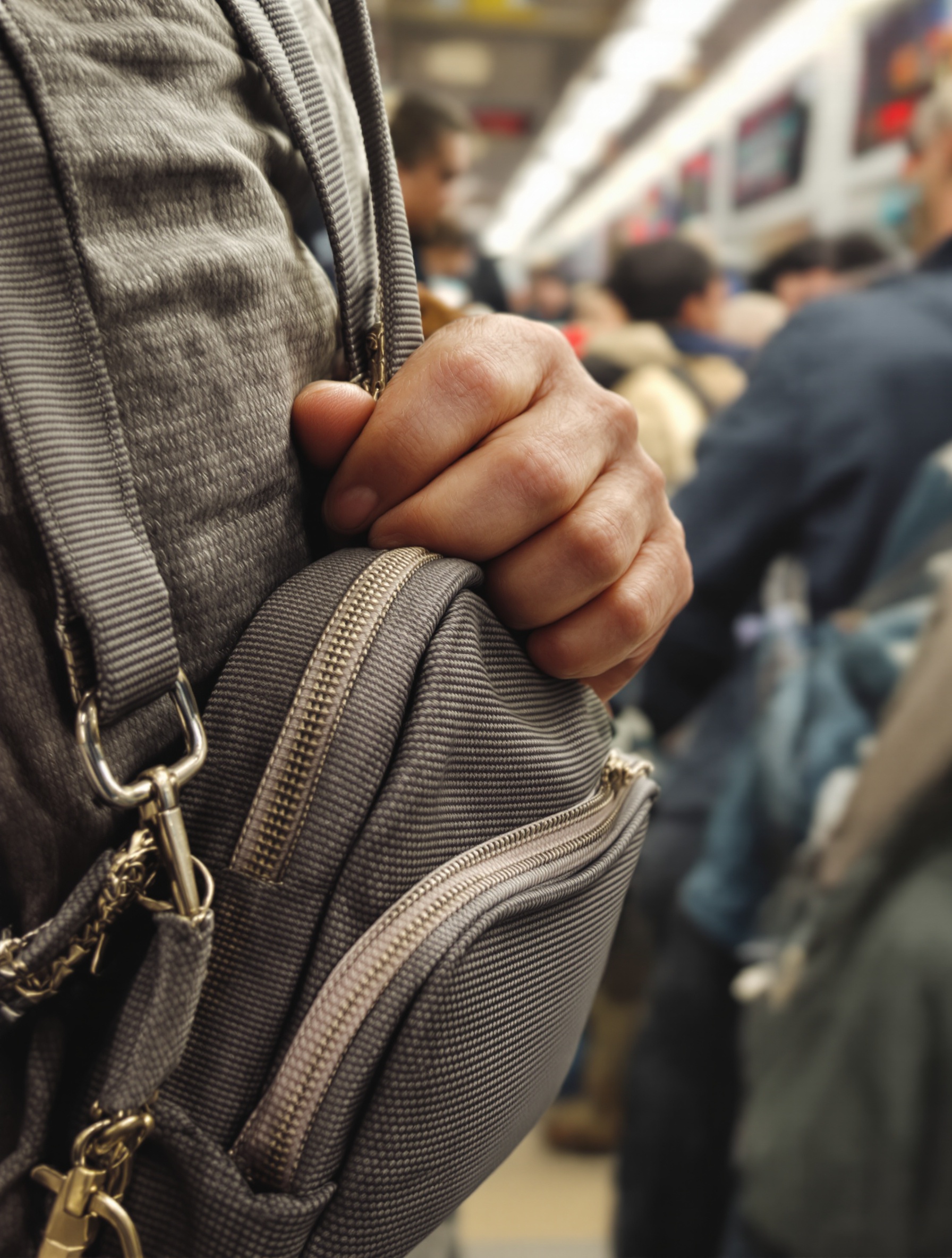 Vigilance : main sur un sac porté devant soi dans un tram bondé à Turin