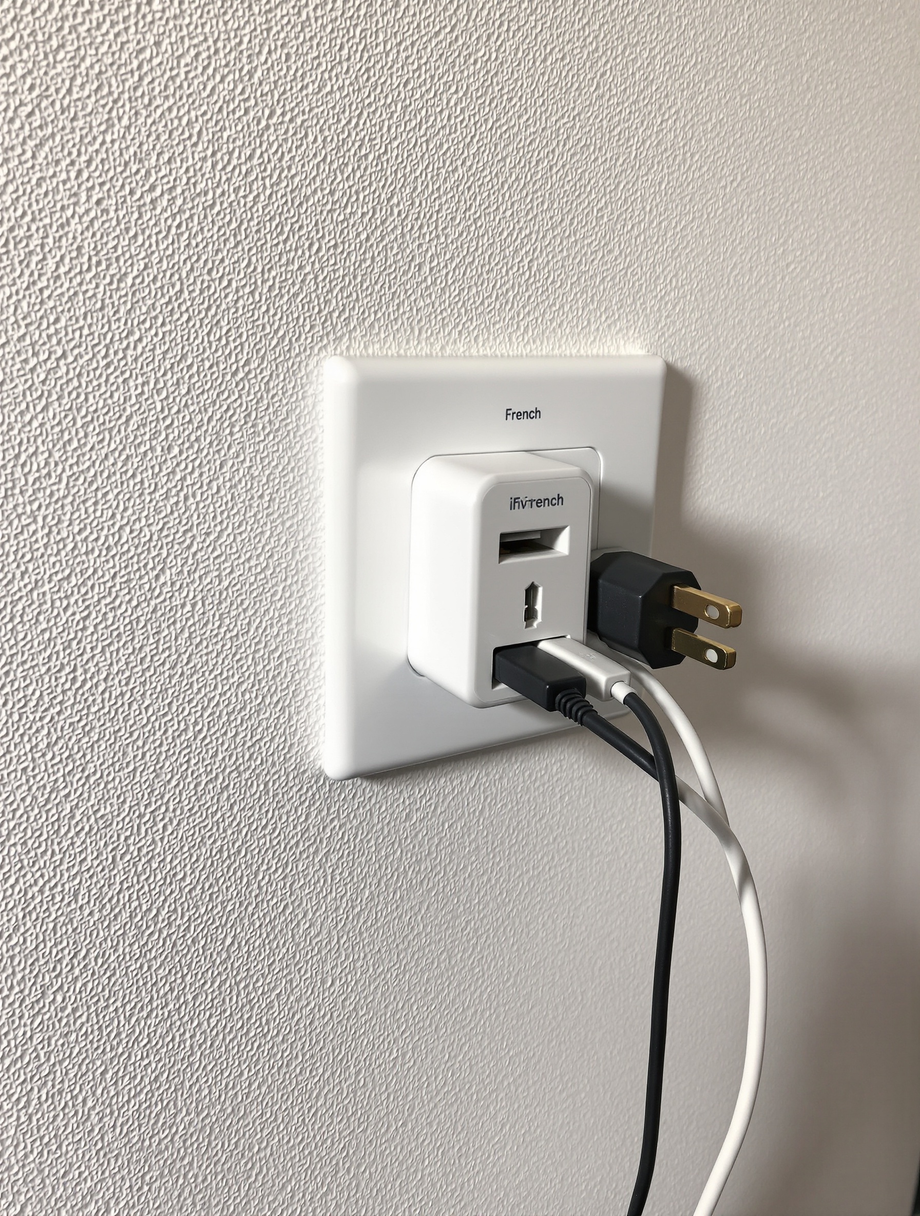 Une petite multiprise de voyage française branchée sur une prise murale hollandaise. Plusieurs appareils (chargeur de téléphone, d'ordinateur) sont connectés à la multiprise, illustrant la praticité de l'astuce.
