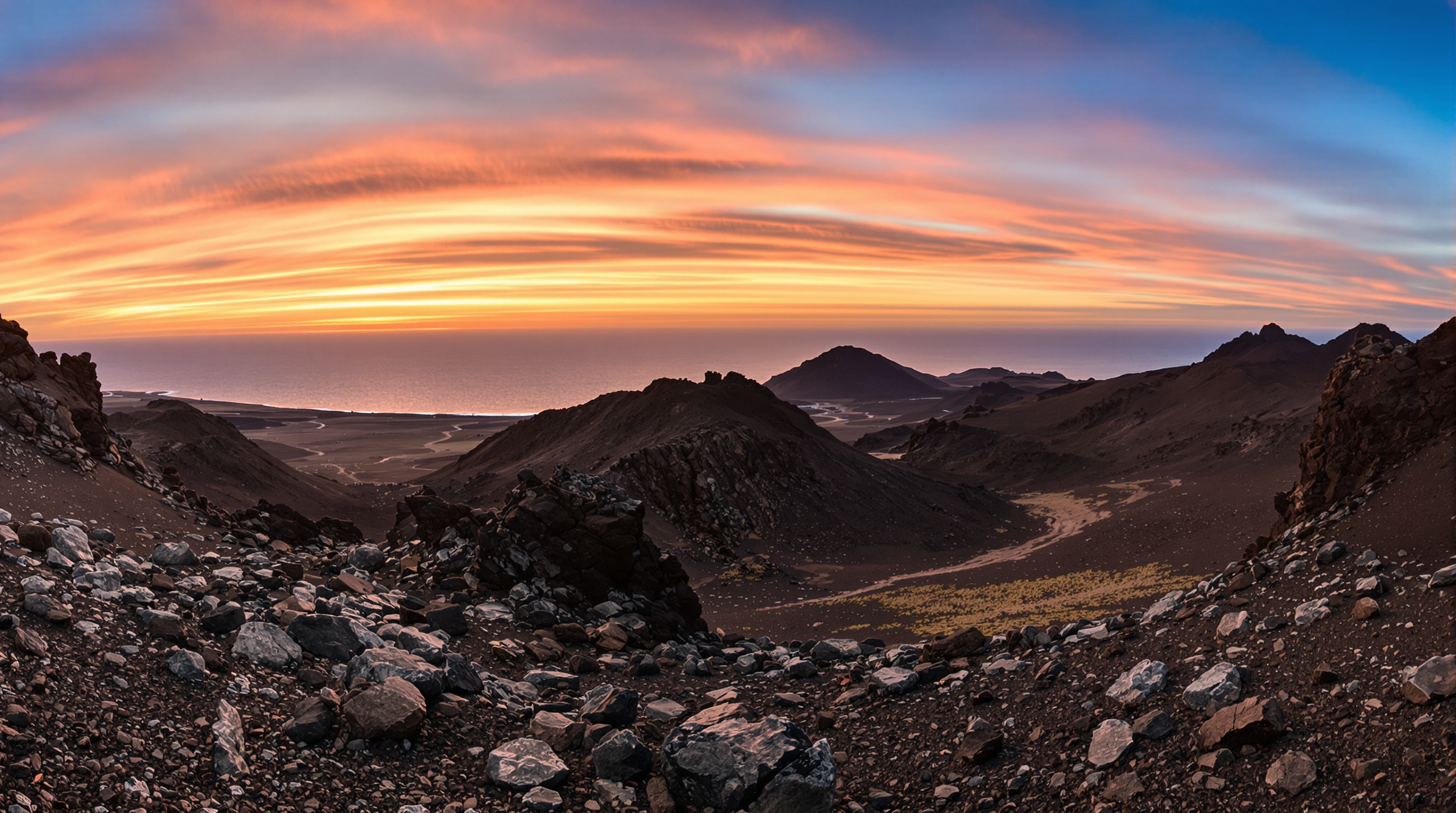 Vue panoramique sur les paysages volcaniques arides de l'Île de l'Ascension, avec l'Océan Atlantique Sud en arrière-plan.