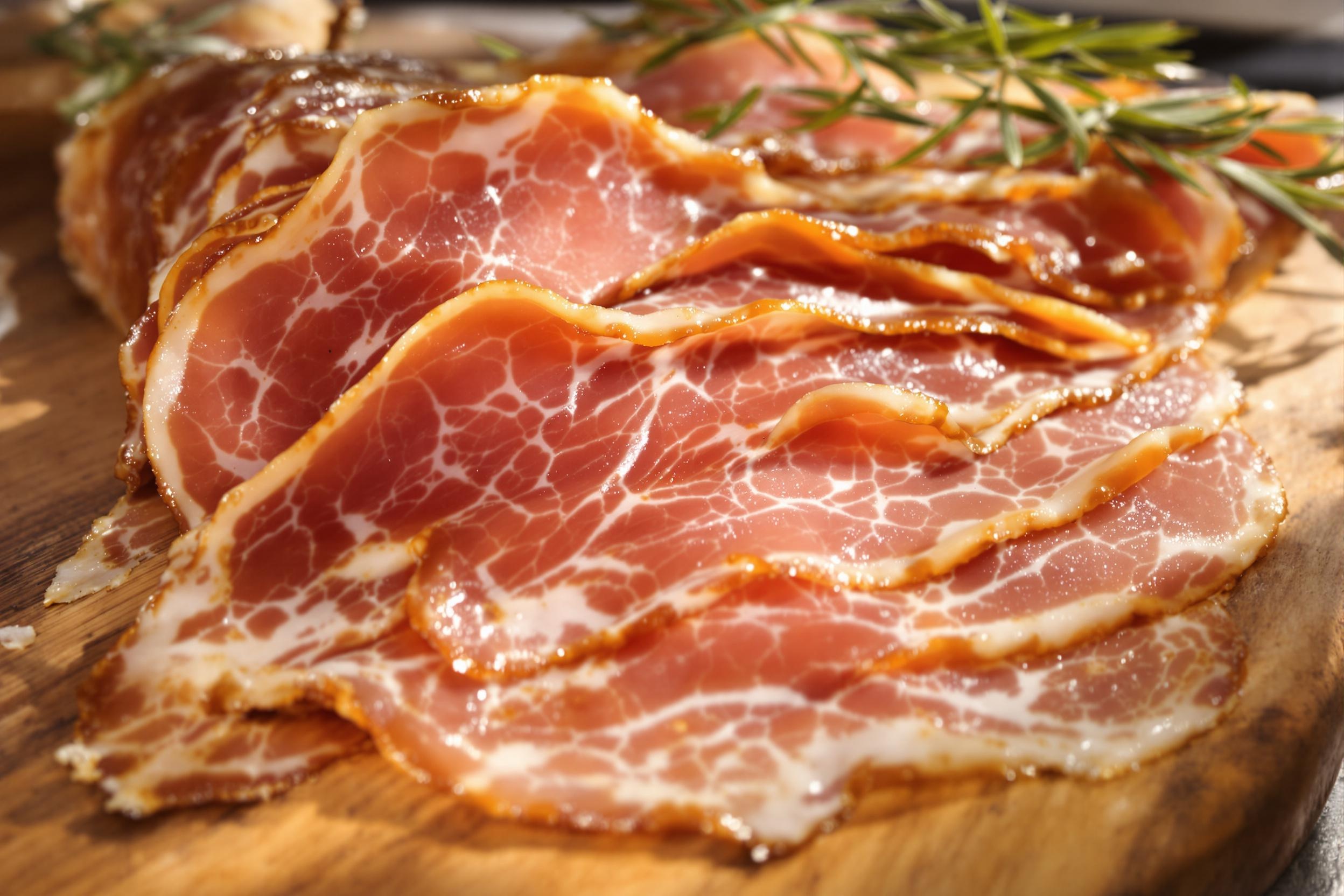 Tranches de jambon de Bosses AOP servies sur planche en bois.