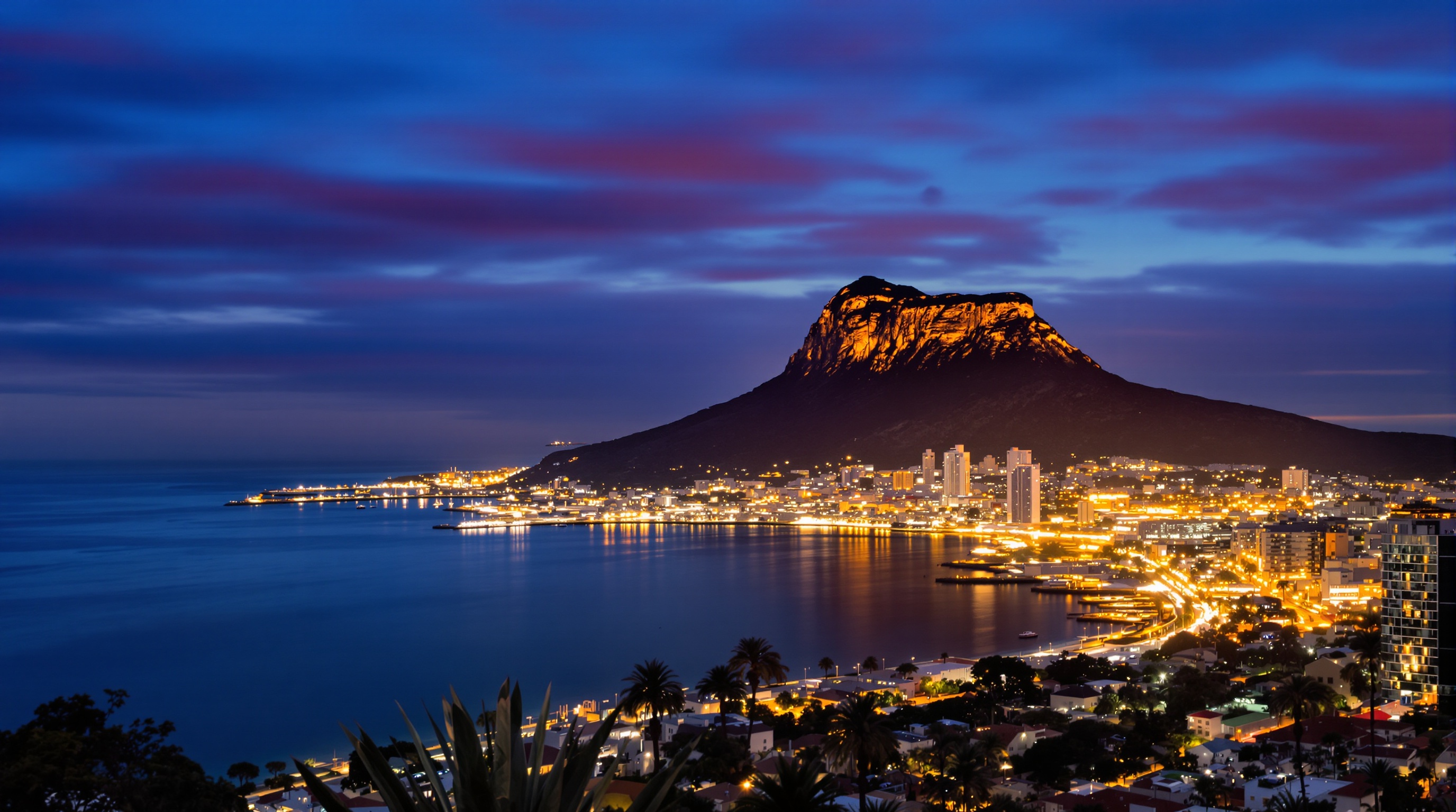 Vue crépusculaire sur la baie de Gibraltar avec Ocean Village illuminé et le Rocher en arrière-plan.