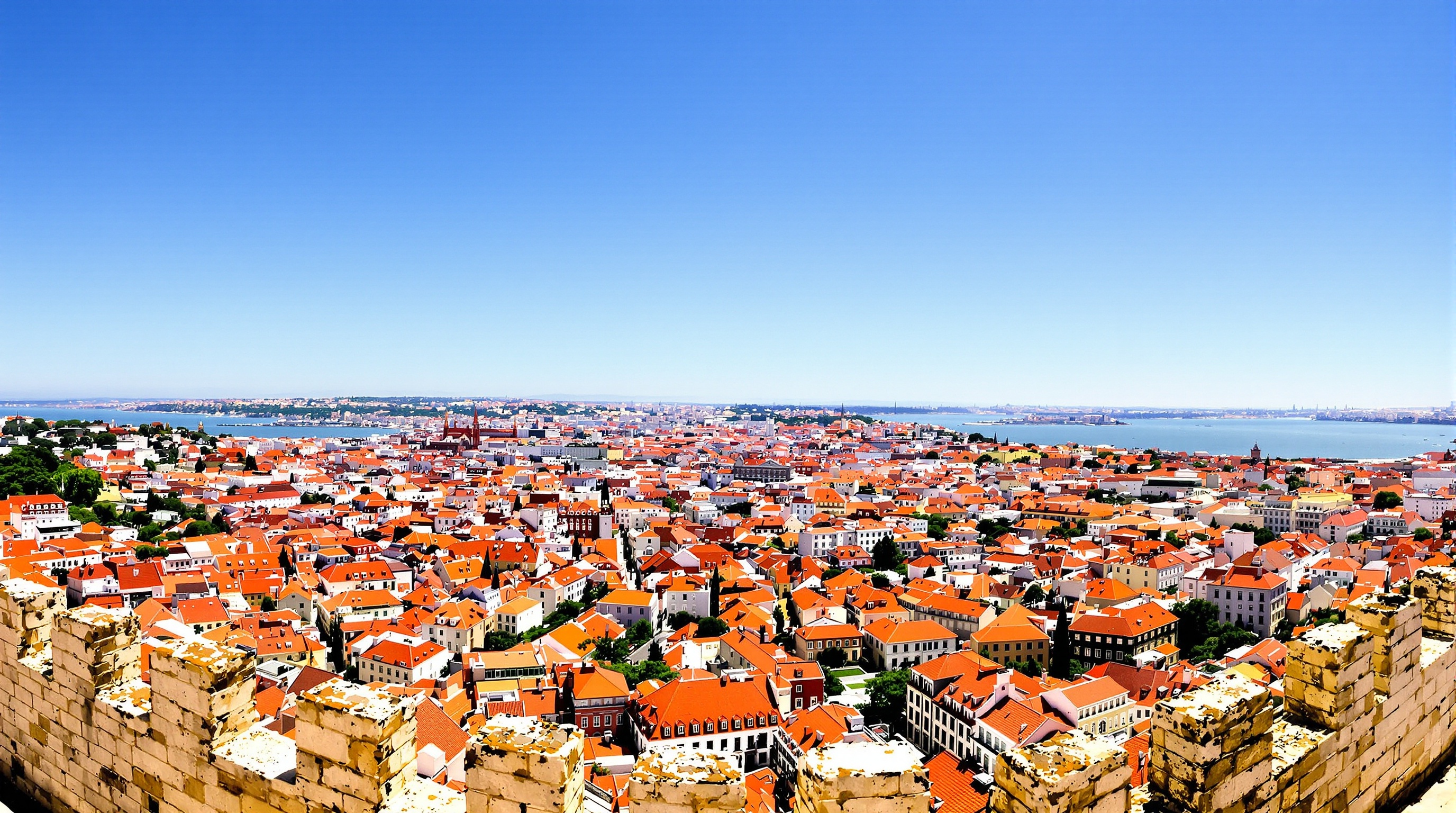 Une vue panoramique spectaculaire depuis les remparts du Château Saint-Georges, montrant les toits rouges de Lisbonne s'étendant jusqu'au fleuve Tage sous un ciel bleu.
